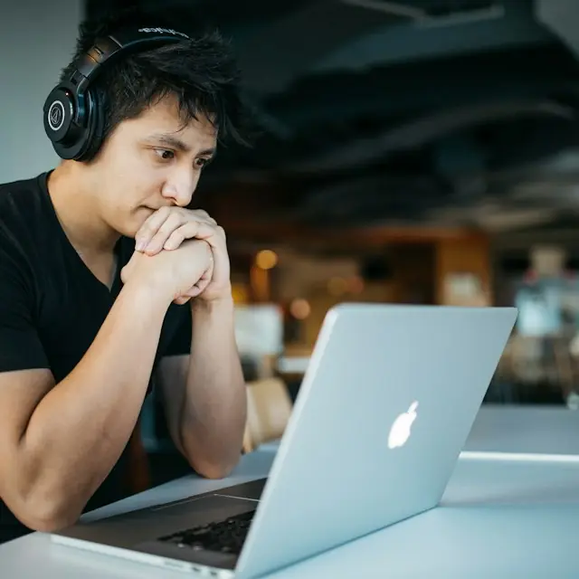 Student with headphones working on a laptop
