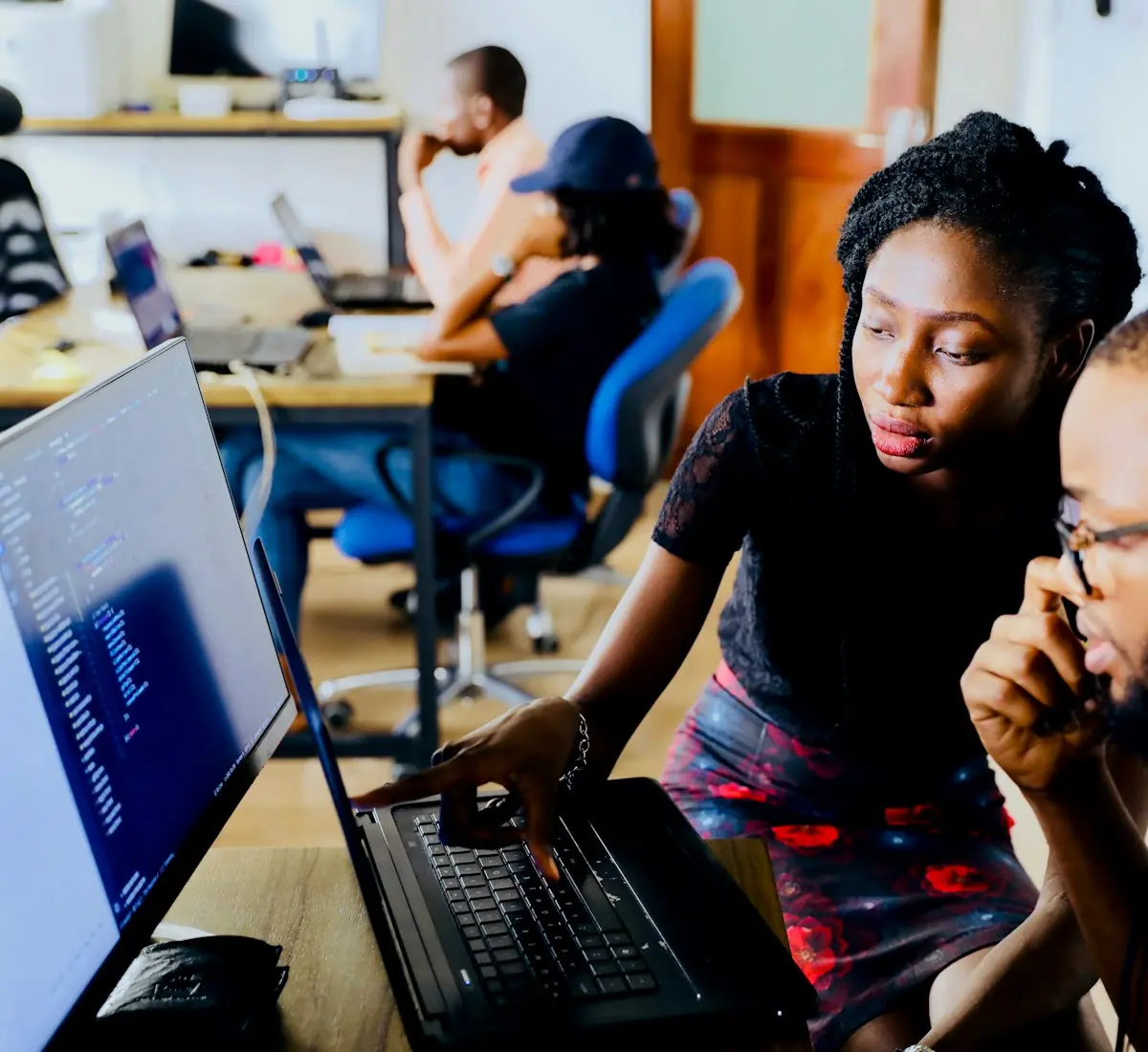 Tutor walking a student through code on a desktop screen